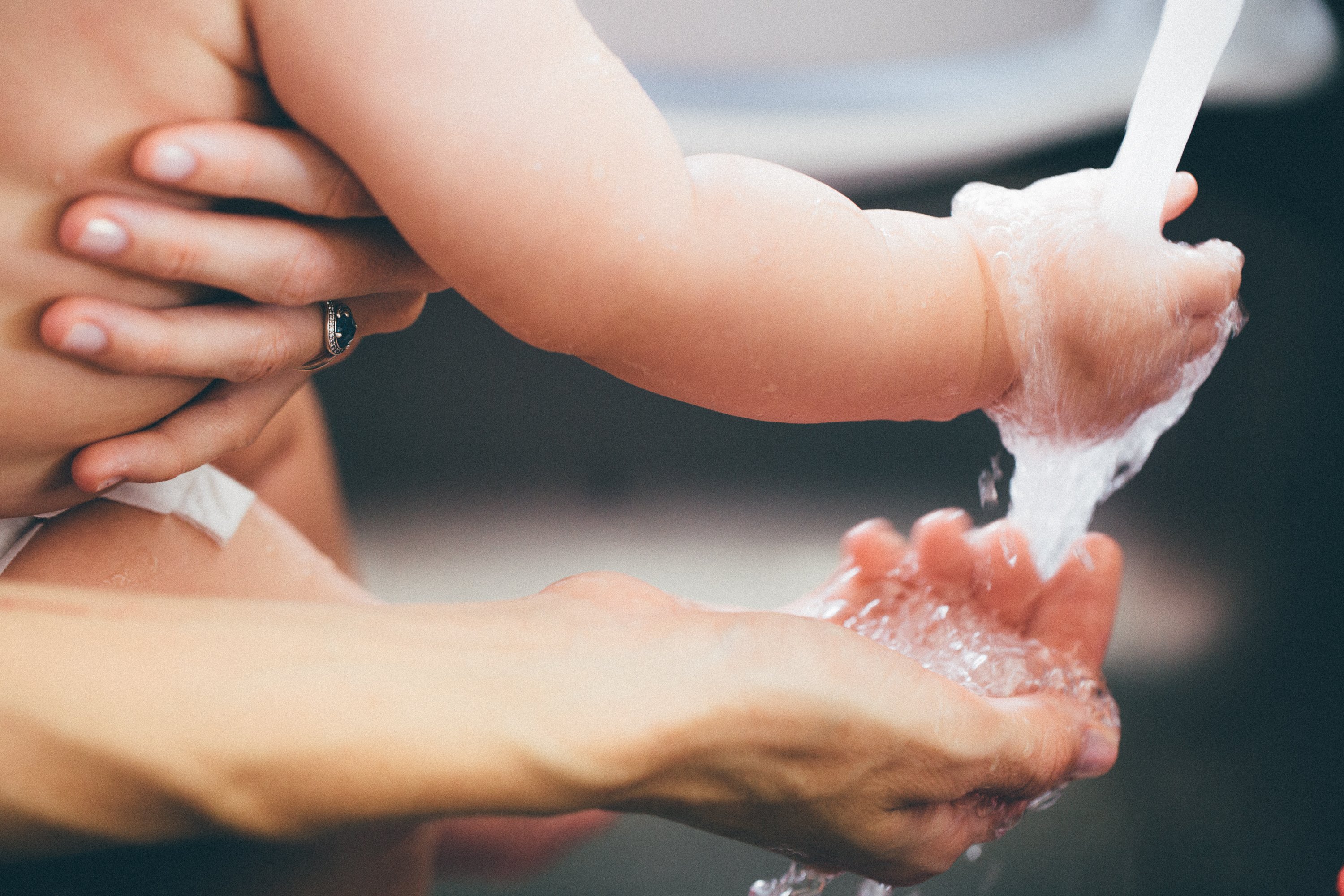 baby and caretaker washing hands