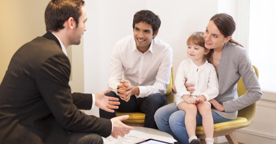 young family sitting with bank employee