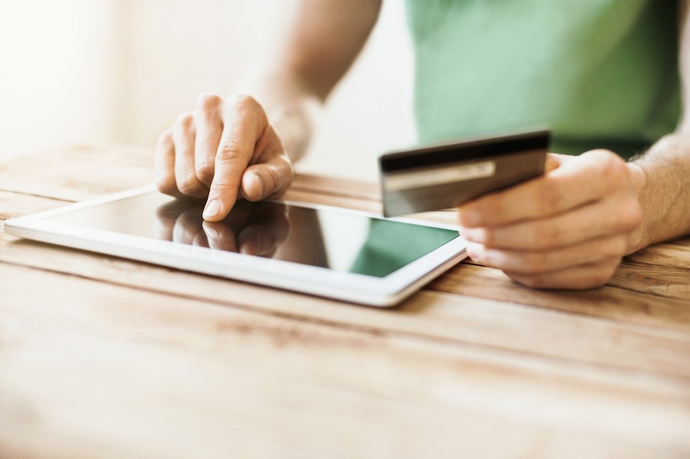 woman entering card information onto tablet